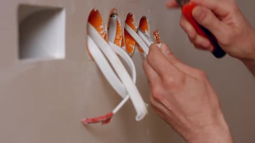 Electrician Stripping Wires With Utility Knife
