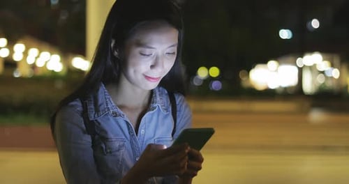Woman Typing on Mobile Phone at Night