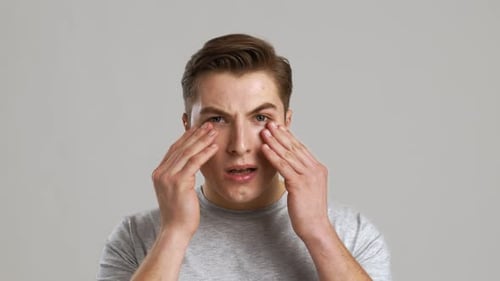 Man Rubbing Eyes in a Close Up Shot