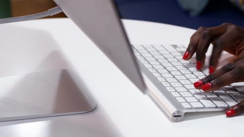 Hände weiblicher Führungskräfte, die am Schreibtisch auf der Tastatur tippen