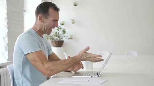 Man Angrily Working on Laptop in Office