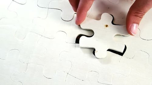 Frau legt fehlendes Teil in ein Puzzle