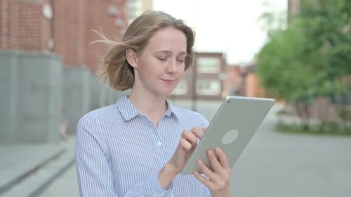 Portrait of Attractive Woman Using Tablet While Walking in Street