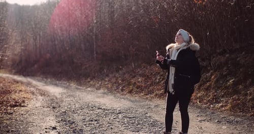 Woman Takes Photo in the Forest During Winter