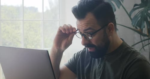 Man Using Laptop in Bright Home Setting
