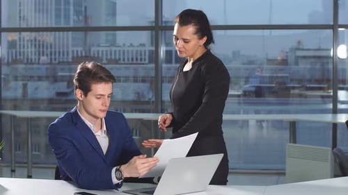 Young Office Colleagues Work with Paper Documents Discussing a New Strategy