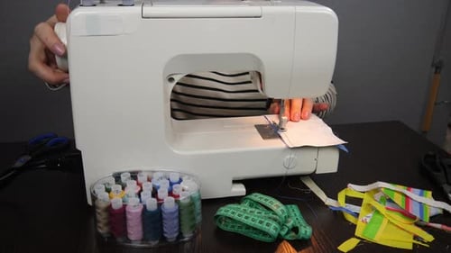 Fashion designer in the studio sews clothes