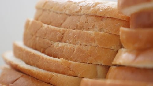 Fresh white oasting bread pieces close-up food background slow tilt 4K 2160p 30fps UHD footage - Til