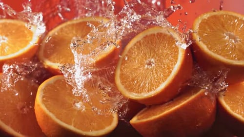 Slow Motion Shot of Water Splashing Through Orange Slices
