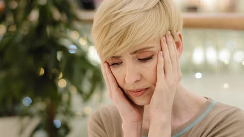 Worried Woman Holding Head in Hands Close Up