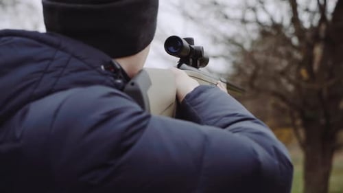 Hunter with gun on forest. Close up of the hunter man shooting with hunting rifle on nature