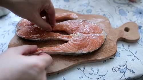 Preparing Fresh Salmon Steaks on Wooden Cutting Board