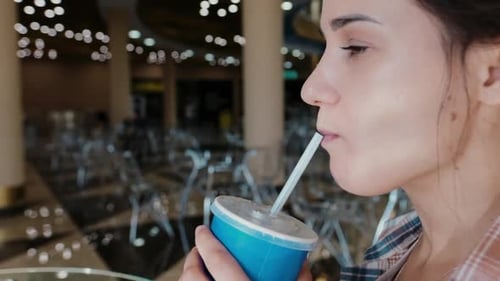 Young Woman Enjoying a Drink with a Straw. Drink Cola or Soda Through a Straw. Close Up the Portrait