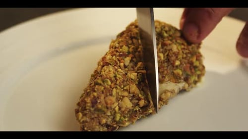 Chef Slicing Nut Crusted Dish on Plate
