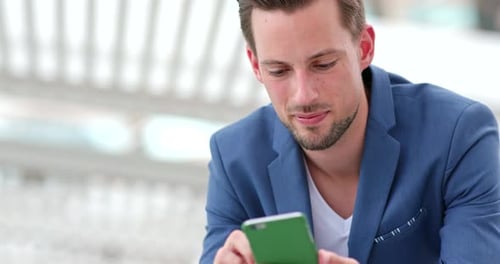 Man Using Smartphone in Sunny Urban Environment