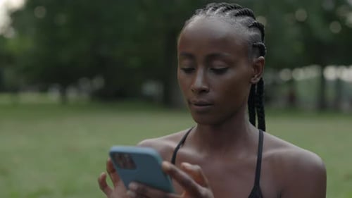 Woman Using Smartphone in Urban Green Space
