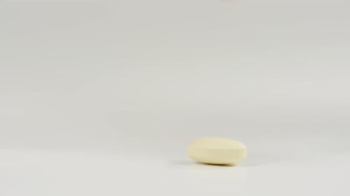 Hand Picking Up Light Yellow Pill