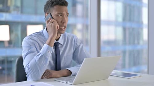 African American Businessman Talking on Cellphone in Office