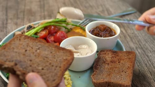 Close Up of Knife Spreading Butter Onto Piece of Wholegrain Toast