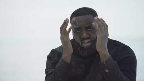 Un homme afro-américain pleure désespérément, victime d'une catastrophe a tout perdu