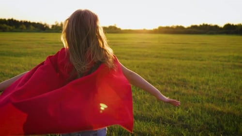 Girl Running with Cape in Sunset Field