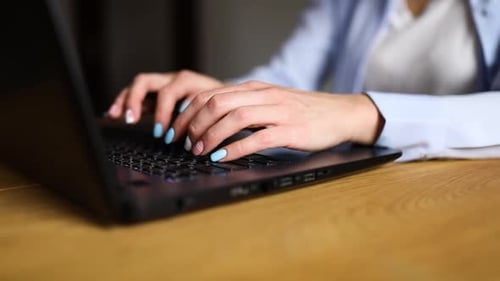 Hands Typing on a Laptop Keyboard at Desk