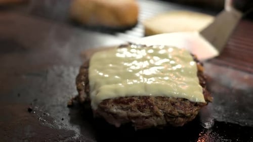 Burger Patty with Melting Cheese on Hot Grill