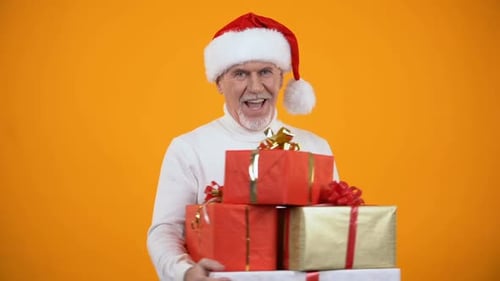 Senior Man with Christmas Gifts in Santa Hat