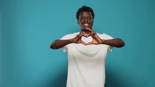 Young Adult Makes Heart Shape With Hands