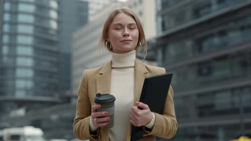 Business Lady Walking on Street with Clipboard and Coffee