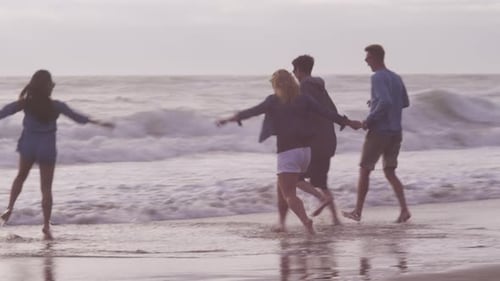 Group of friends at beach running together