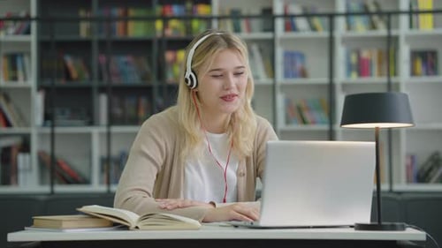 Smiling Young Woman Video Conferencing on Laptop
