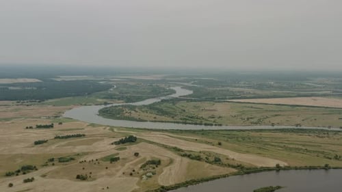 Aerial Landscape, Drone Flies High Over Beautiful Winding River Flows Through Green Meadows, Wheat