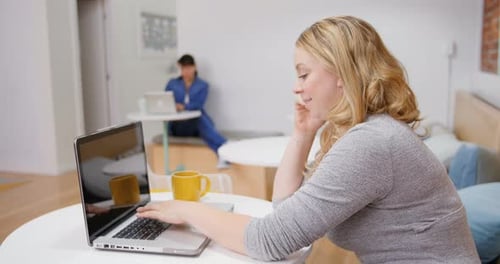 Woman Works on Laptop in Modern Office