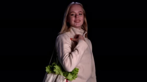Woman Smiling and Holding Bag of Lettuce