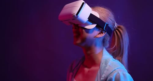 Young Asian woman playing metaverse virtual reality digital technology game with VR goggle.