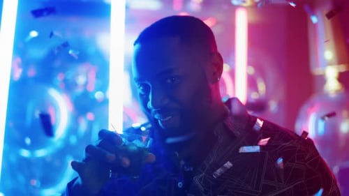 Afro Guy Drinking Alcohol in Club. Man Raising Up Glass on Neon Background.