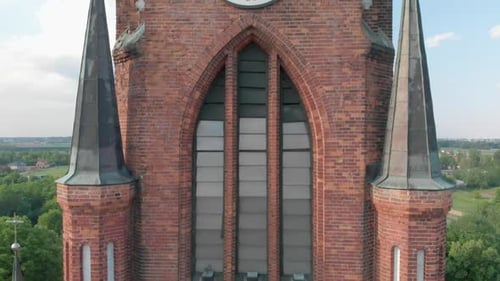 Kirche in einer kleinen Stadt zwischen Weiden. Drohnen-Aufnahmen. Rote Kirche ist römisch-katholische Kirche.