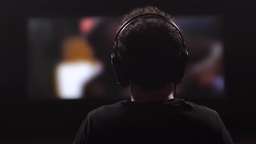 человек в наушниках смотрит фильм