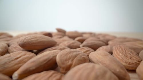 Falling Almonds Close Up on Wooden Table