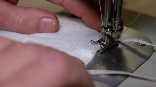 Adult Hands Sewing White Fabric on Machine