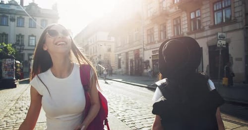 Young Women Explore Urban Streets on Sunny Day