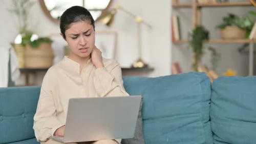 Woman Uses Laptop, Experiences Neck Pain on Couch