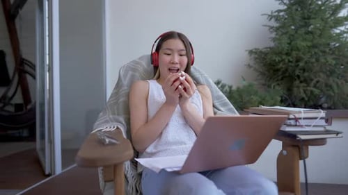Young Woman with Laptop and Apple Indoors