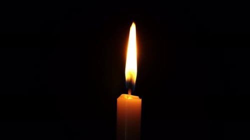 Candle Flame Flickering Against a Dark Background