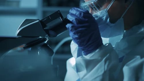 Scientist Using Microscope in Dark Laboratory