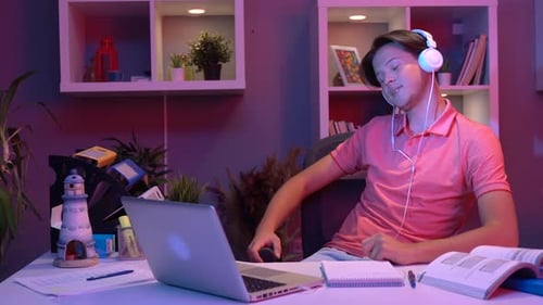 Teen Communicates on Laptop Wearing Headphones