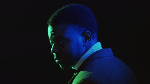 Smiling Young Adult in Green and Blue Lighting