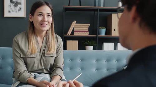 Woman Talking in Therapy Session on Blue Couch