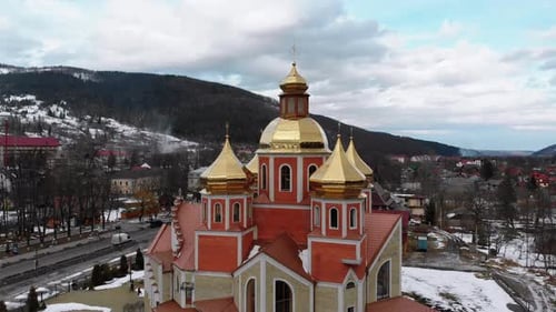 Aerial Drone View of Ukrainian Church with Golden Domes in Carpathian Village in Winter